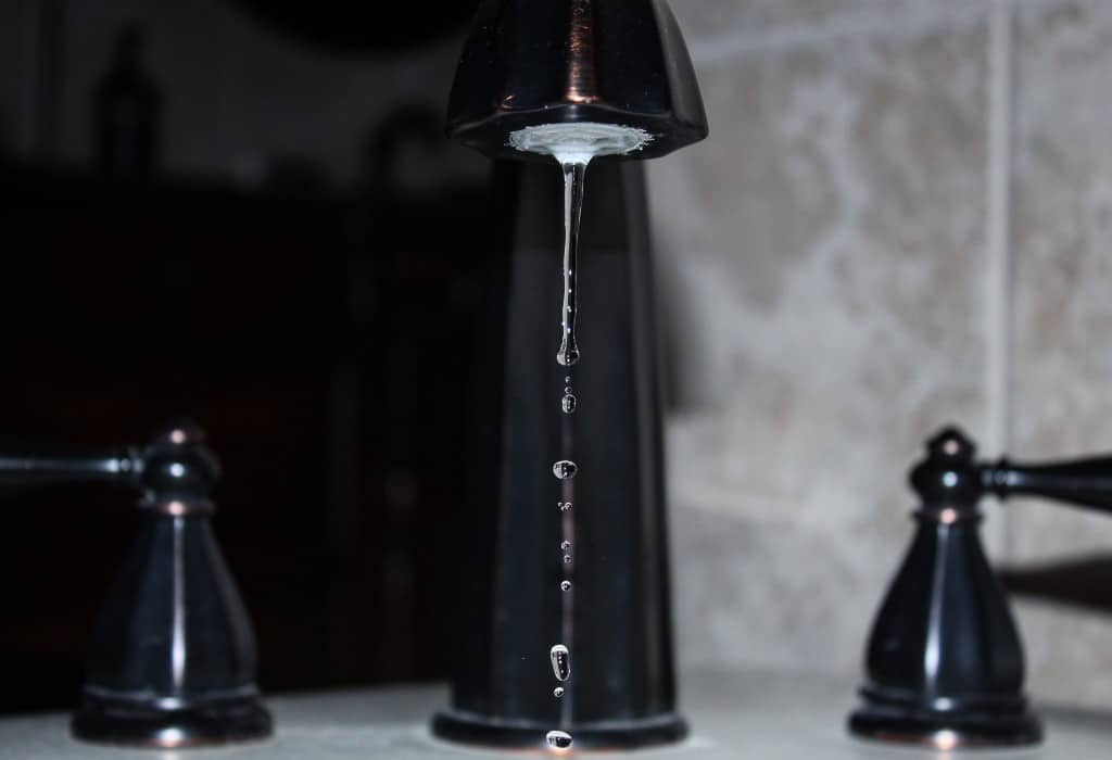 A black faucet dripping water